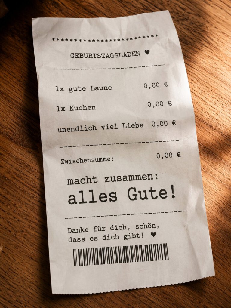 Kassenbon-Illustration mit Aufschrift Geburtstagsladen: 1x gute Laune, 1x Kuchen, unendlich viel Liebe, macht zusammen alles Gute